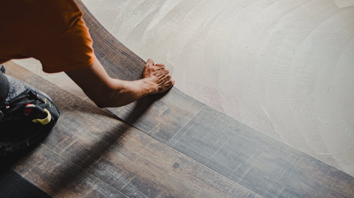 Craftsman installing luxury vinyl plank flooring